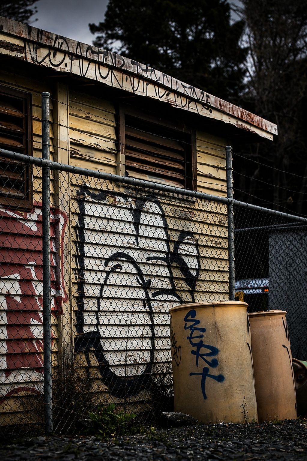 A graffiti-marked shack behind wire